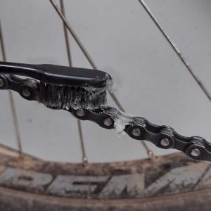 Aplicando cera de corrente com escova